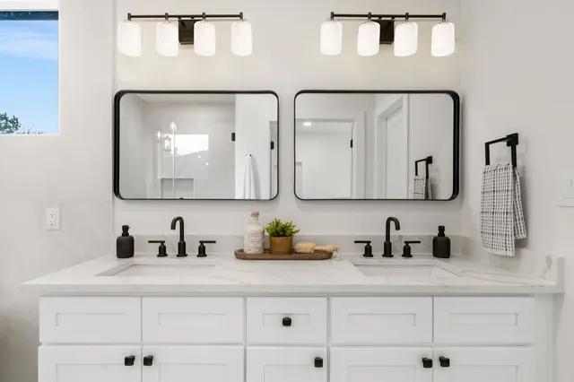 a bathroom with double vanity sinks and a mirror
