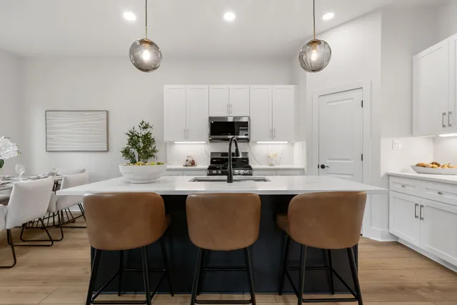 a kitchen with granite countertop a table and chairs in it