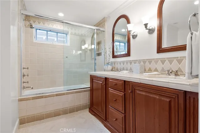 a bathroom with a glass door shower a sink and a mirror