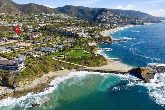 an aerial view of a house with garden space and a car park side of the road