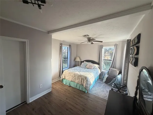 a bedroom with a bed and wooden floor