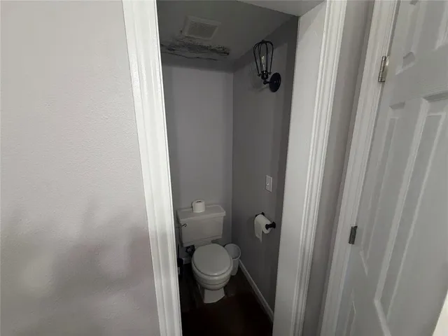 a bathroom with a granite countertop toilet and a shower