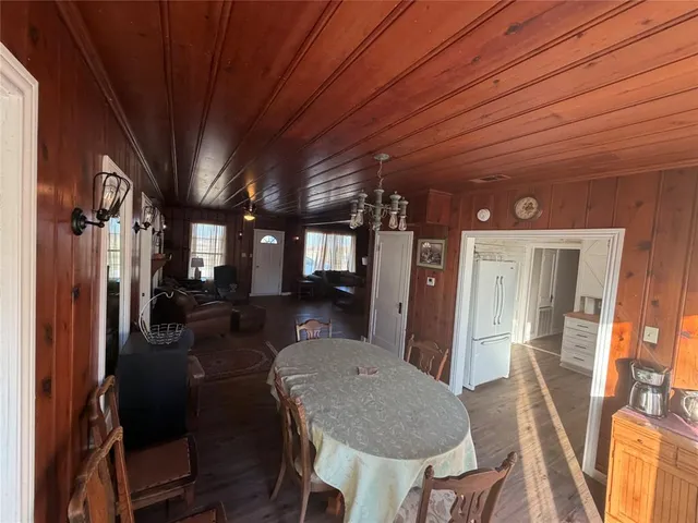 a view of a dining room with furniture a chandelier and wooden floor