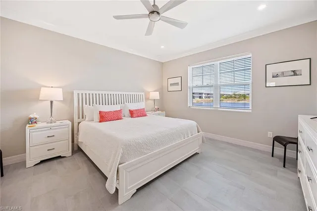 a bedroom with a white bed and dresser with mirror