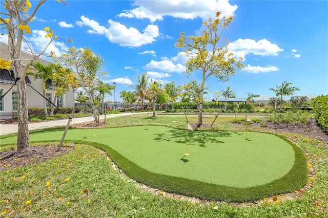 a view of swimming pool with lawn chairs and plants
