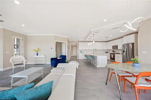 a living room with furniture and kitchen view