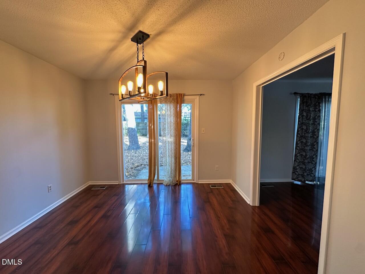 3717 Sue Ellen Drive Raleigh, NC 27604 - Photo 10 of 20 a view of an empty room with wooden floor and a window
