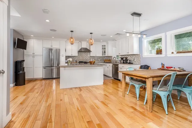 a large kitchen with cabinets wooden floor and stainless steel appliances