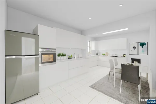 a large white kitchen with cabinets and stainless steel appliances