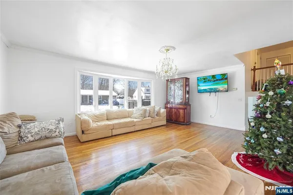 a spacious bedroom with a bed chandelier and couch