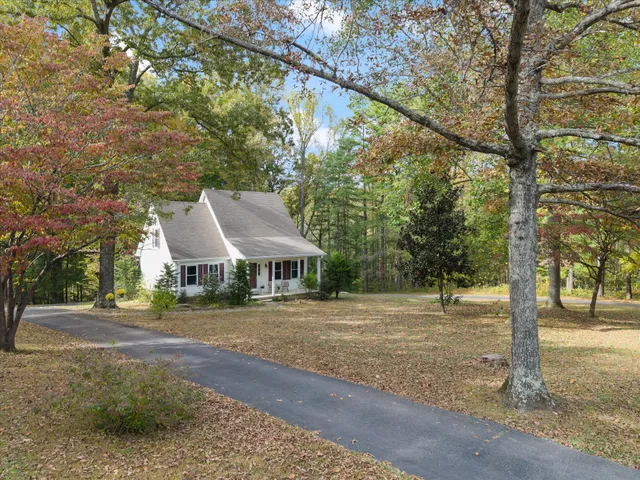 a front view of a house with a yard and trees