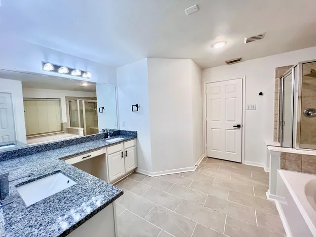 a spacious bathroom with a granite countertop sink and mirror