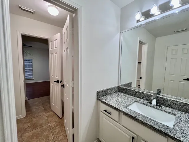 a bathroom with a granite countertop sink and a mirror