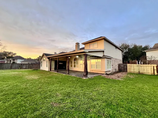 a view of a house with a big yard and large trees