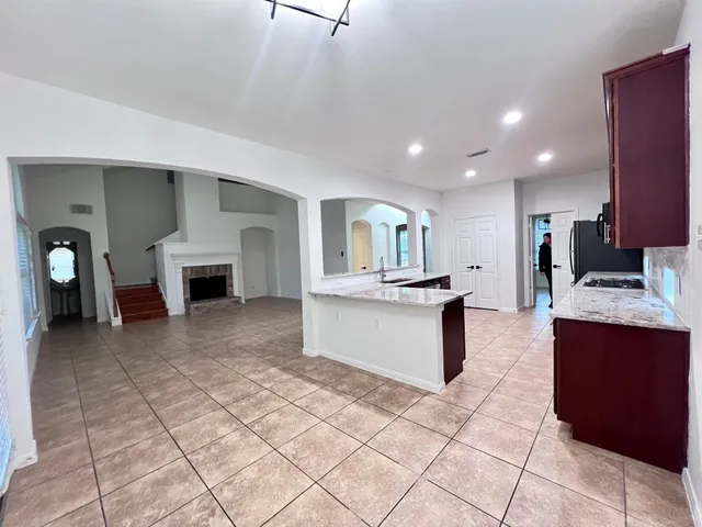 a large kitchen with stainless steel appliances kitchen island granite countertop a refrigerator and a sink