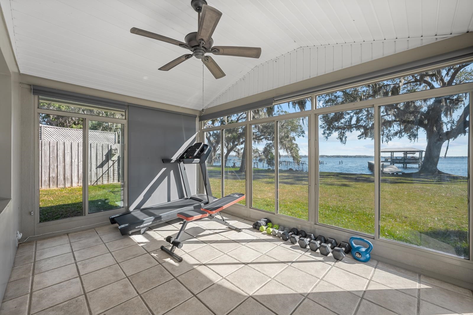 130 Cedar Creek Road Palatka, FL 32177 - Photo 22 of 73 Exercise area featuring a water view, vaulted ceiling, tile patterned floors, a ceiling fan, and a sunroom
