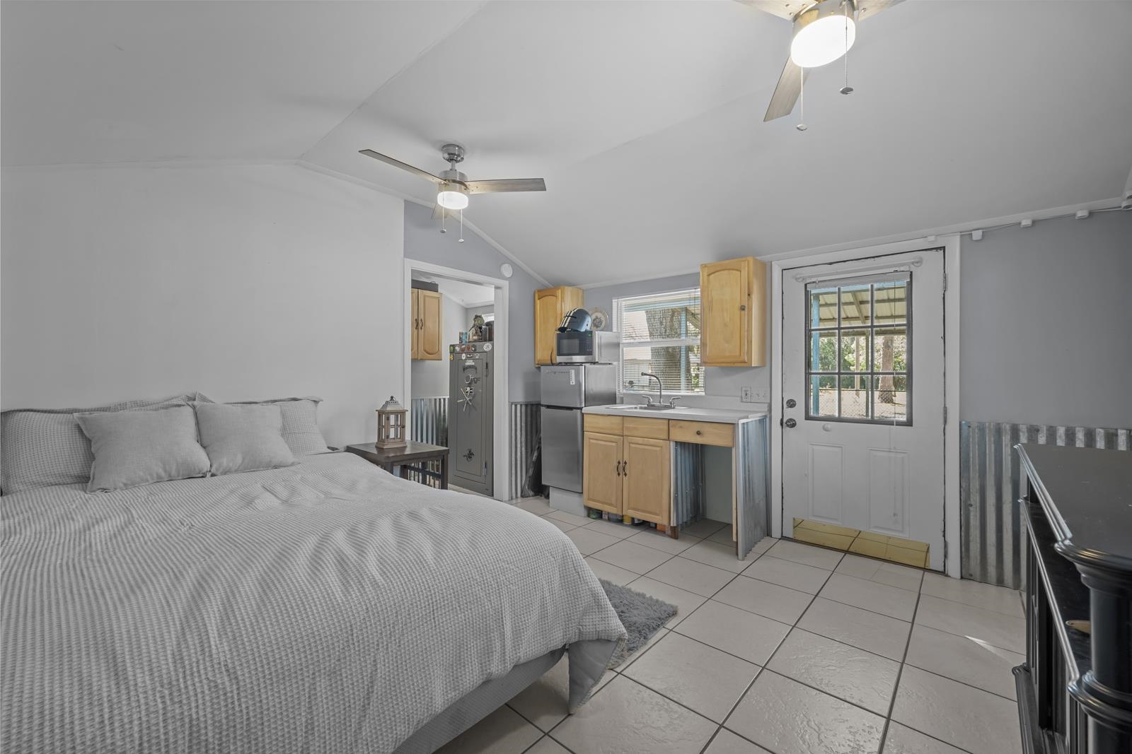 130 Cedar Creek Road Palatka, FL 32177 - Photo 48 of 73 Bedroom with lofted ceiling, freestanding refrigerator, light tile patterned flooring, and a ceiling fan