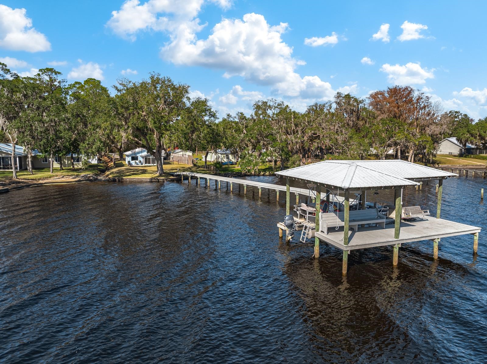 130 Cedar Creek Road Palatka, FL 32177 - Photo 60 of 73 a view of a patio with table and chairs with wooden floor and fence