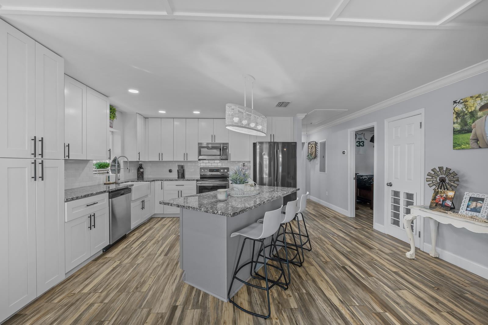 130 Cedar Creek Road Palatka, FL 32177 - Photo 8 of 73 a kitchen with stainless steel appliances kitchen island granite countertop a refrigerator a stove a sink and white cabinets with wooden floor