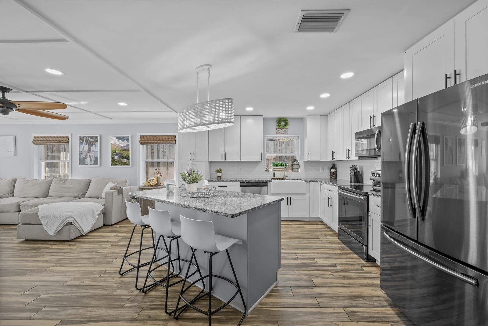 130 Cedar Creek Road Palatka, FL 32177 - Photo 9 of 73 Kitchen with stainless steel appliances, a breakfast bar area, white cabinetry, light stone countertops, and a center island