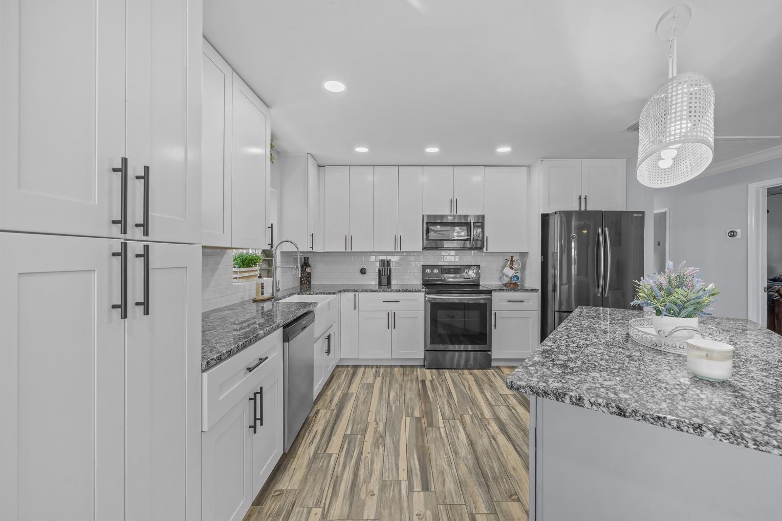 130 Cedar Creek Road Palatka, FL 32177 - Photo 10 of 73 Kitchen featuring stainless steel appliances, white cabinets, dark stone countertops, wood finished floors, and recessed lighting