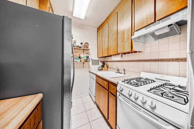 a kitchen with stainless steel appliances a stove a sink and a refrigerator