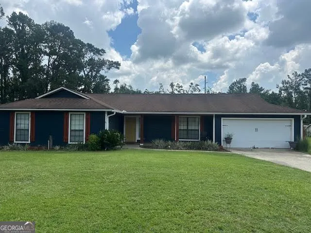 a front view of a house with a yard and trees