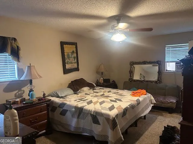 a bedroom with a bed and dresser with mirror