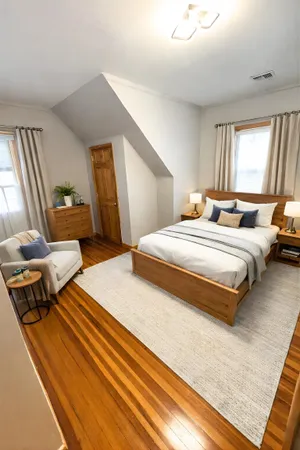 a spacious bedroom with a bed and wooden floor