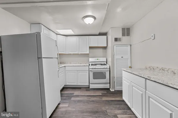 a kitchen with white cabinets and white appliances