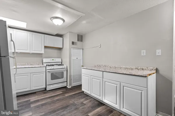 a kitchen with white cabinets and white appliances