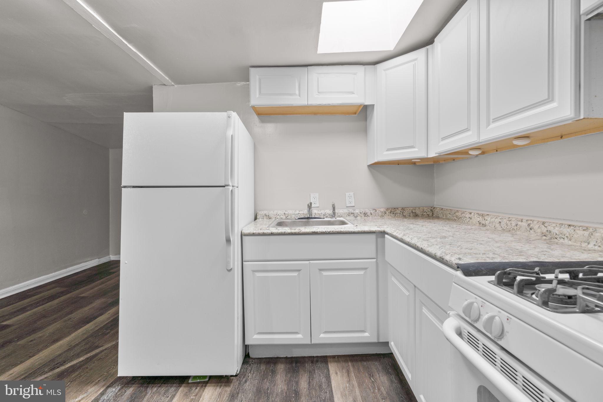 517 Mosher Street Baltimore, MD 21217 - Photo 21 of 45 a kitchen with granite countertop white cabinets and white appliances