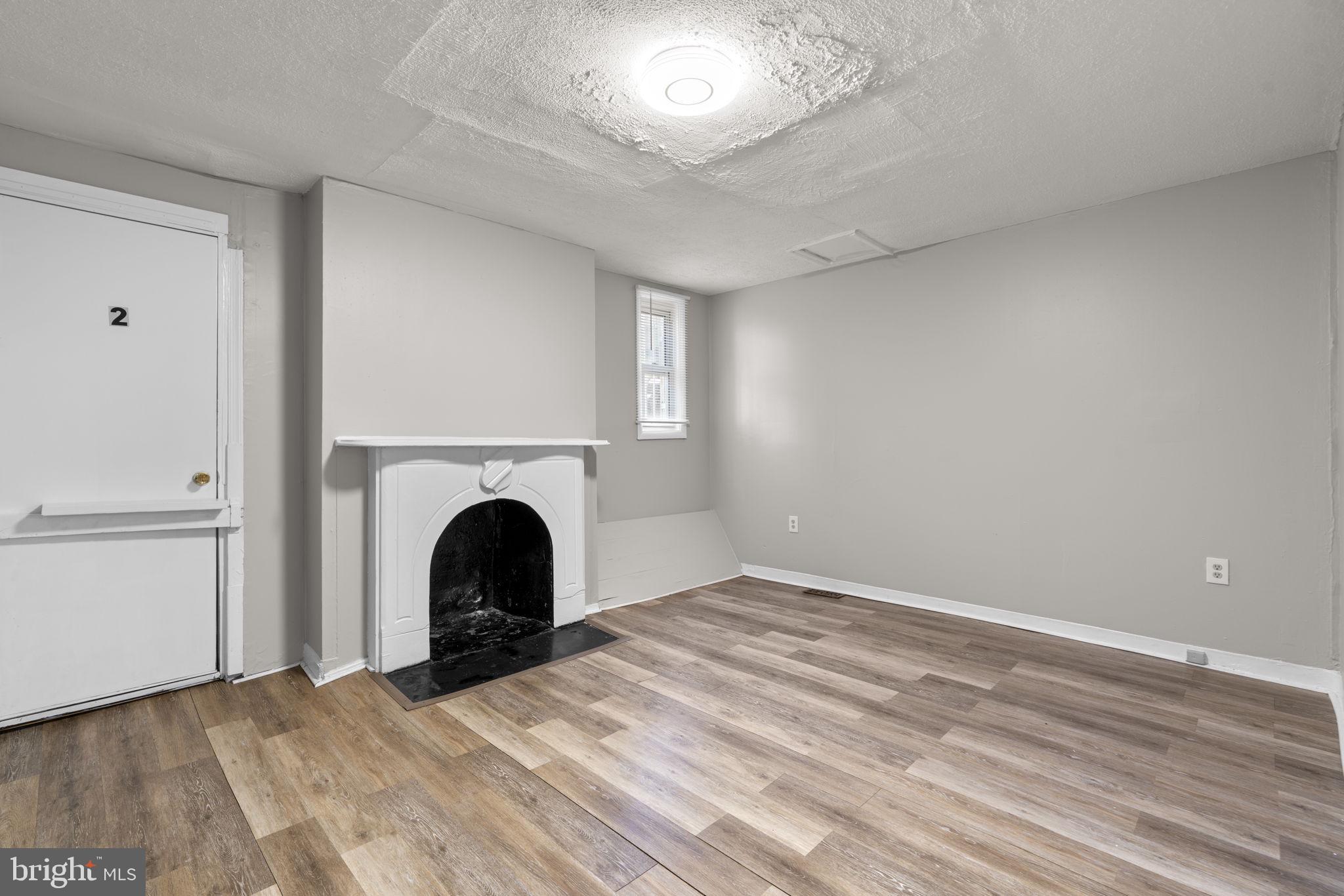 517 Mosher Street Baltimore, MD 21217 - Photo 24 of 45 a view of an empty room with a fireplace and a window