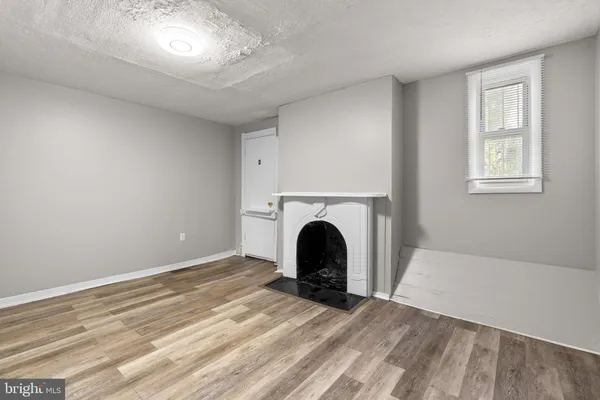 a view of a livingroom with a fireplace and window
