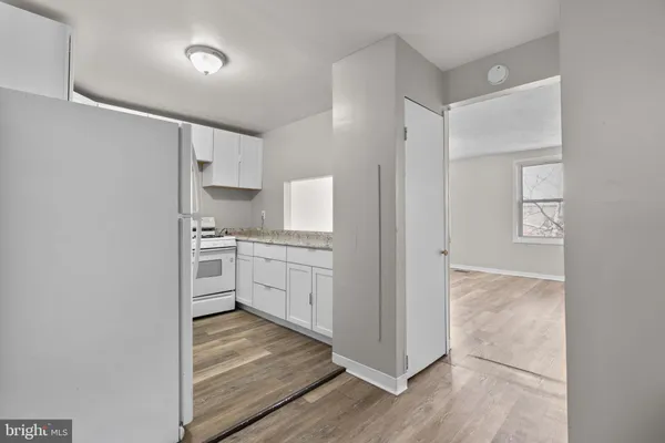 a kitchen with white cabinets and white appliances