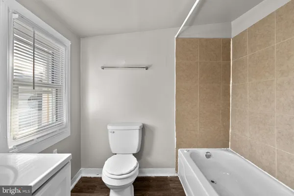 a white toilet sitting next to a bath tub