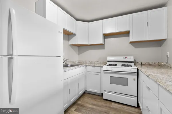 a kitchen with white cabinets and white appliances