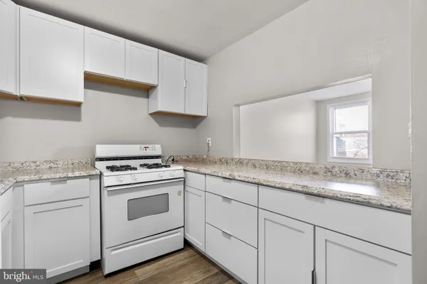 a kitchen with granite countertop white cabinets and white appliances
