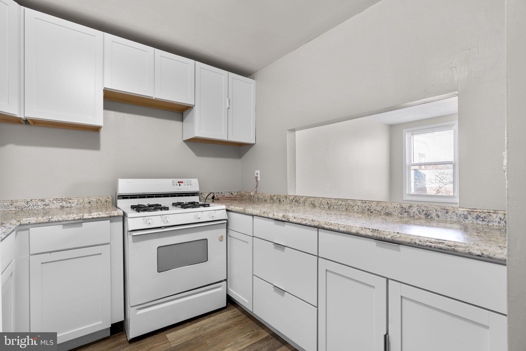 517 Mosher Street Baltimore, MD 21217 - Photo 6 of 45 a kitchen with granite countertop white cabinets and white appliances