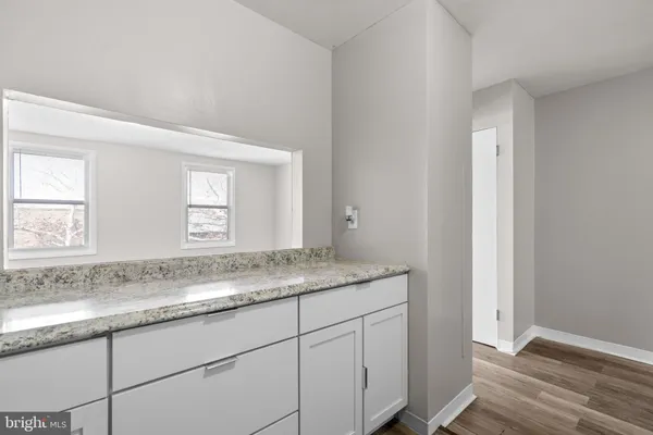 a bathroom with a granite countertop sink and mirror