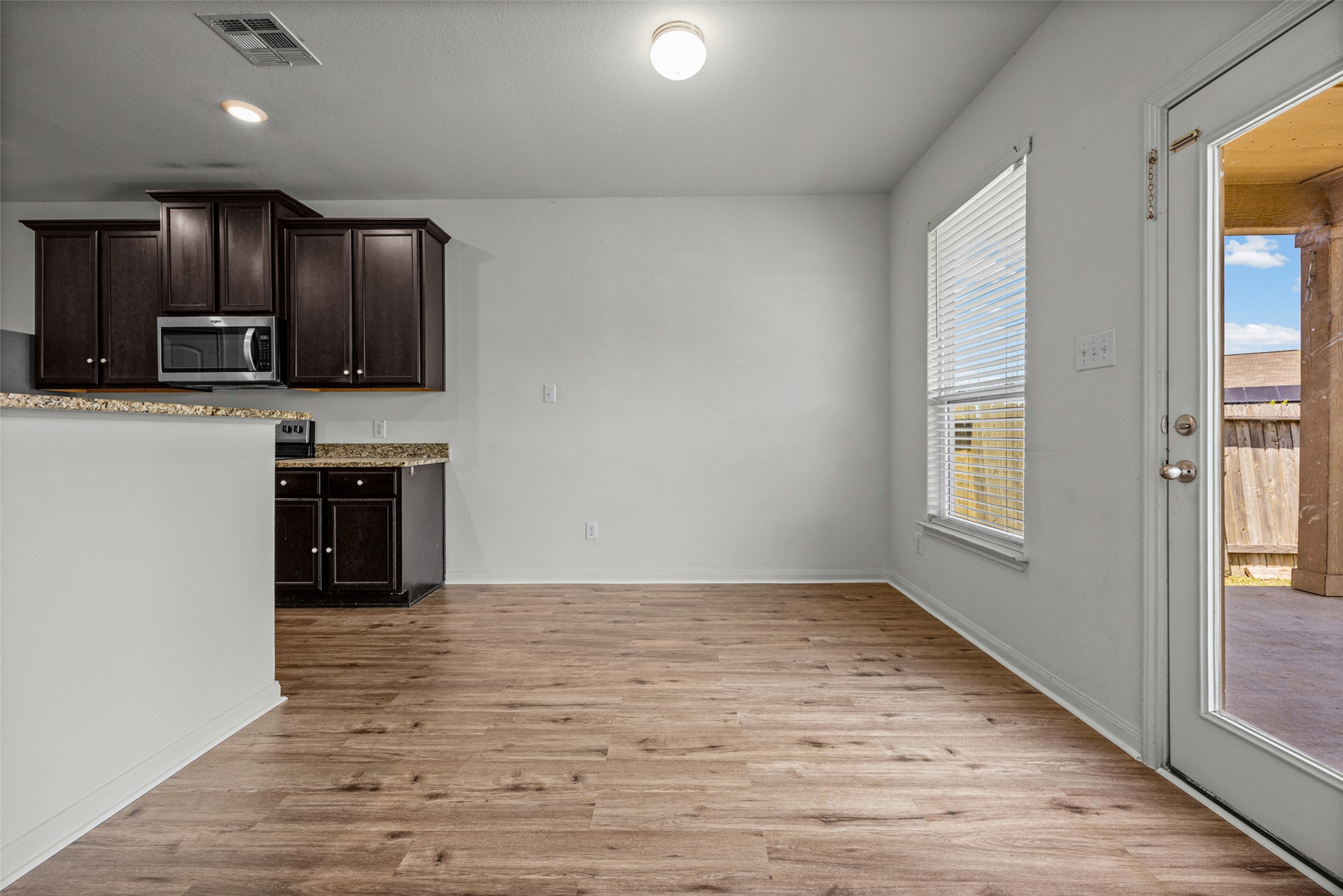 19812 Hubert R Humphrey Road Manor, TX 78653 - Photo 5 of 29 A combined kitchen and dining space offers modern amenities and easy access to the outdoor patio.