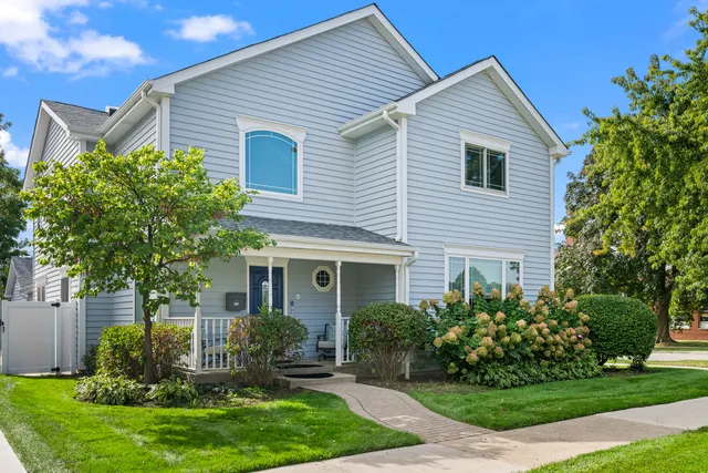 a front view of a house with a yard and potted plants