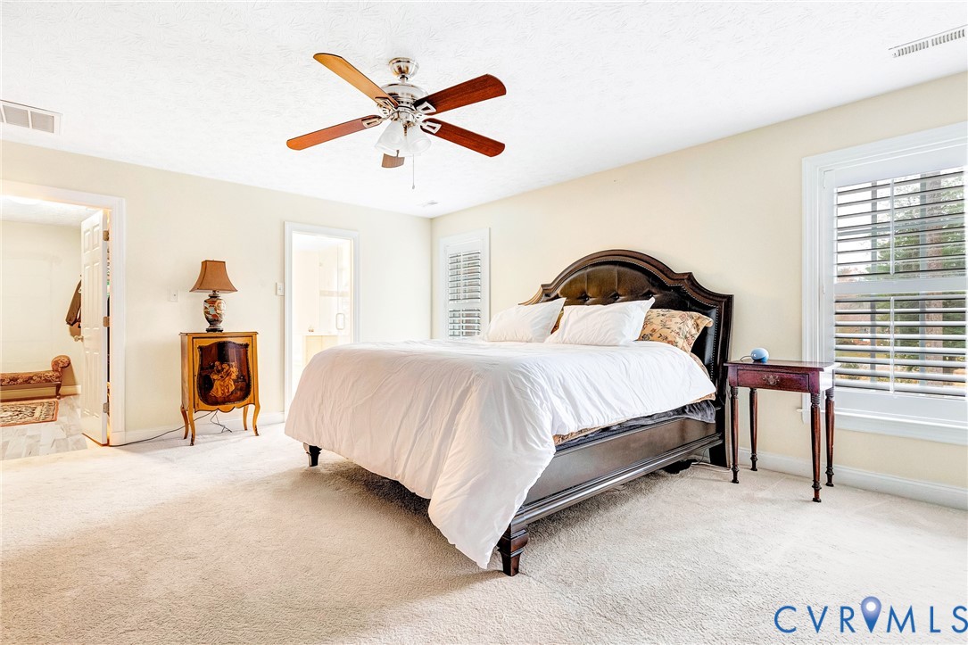 9212 Wyattwood Road Mechanicsville, VA 23116 - Photo 14 of 47 a bedroom with a large bed and a chandelier