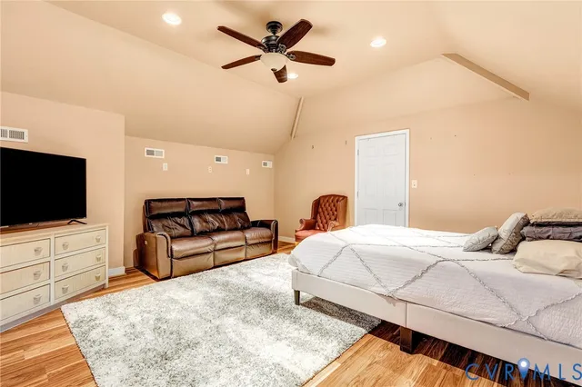 a bedroom with a bed a flat screen tv and a couch