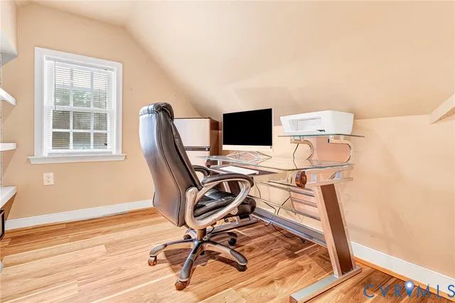 a view of a workspace with furniture and a window