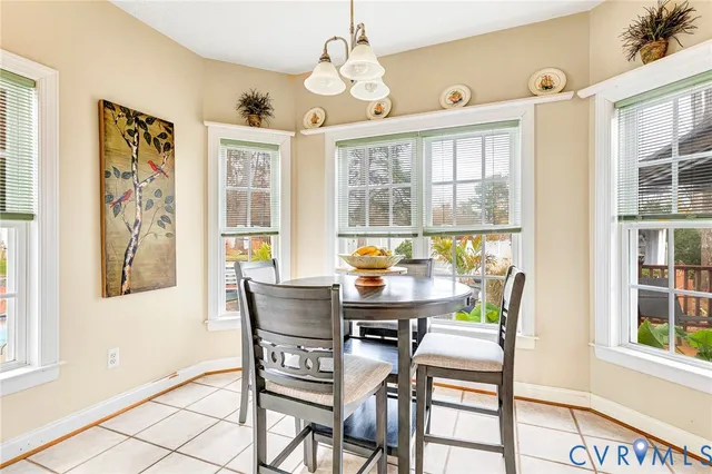 a dining room with chandelier and wooden floor