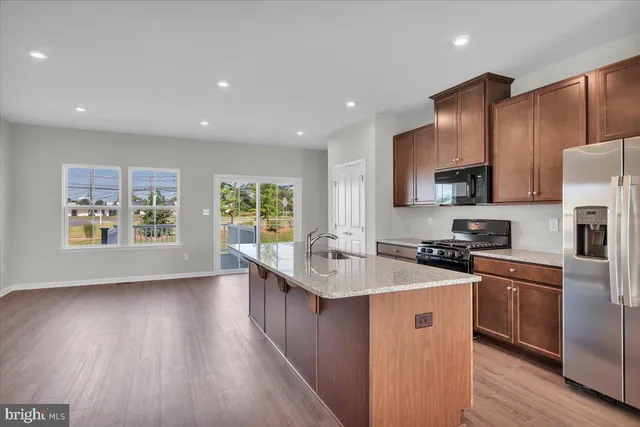 a kitchen with a stove a sink a microwave a refrigerator and cabinets