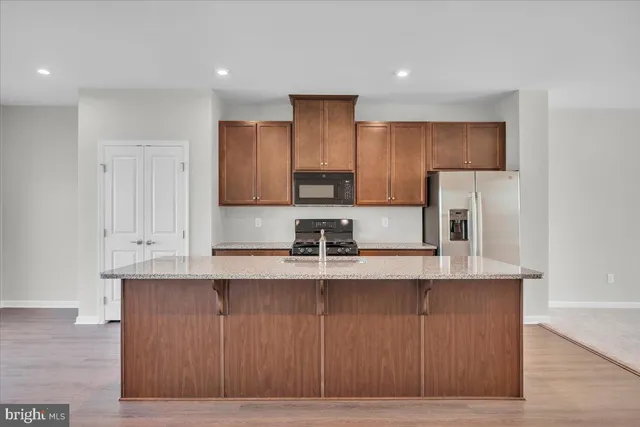 a kitchen with stainless steel appliances granite countertop a stove a sink and a refrigerator