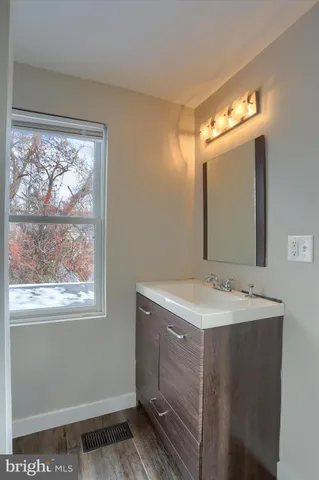 a bathroom with a sink mirror and a window