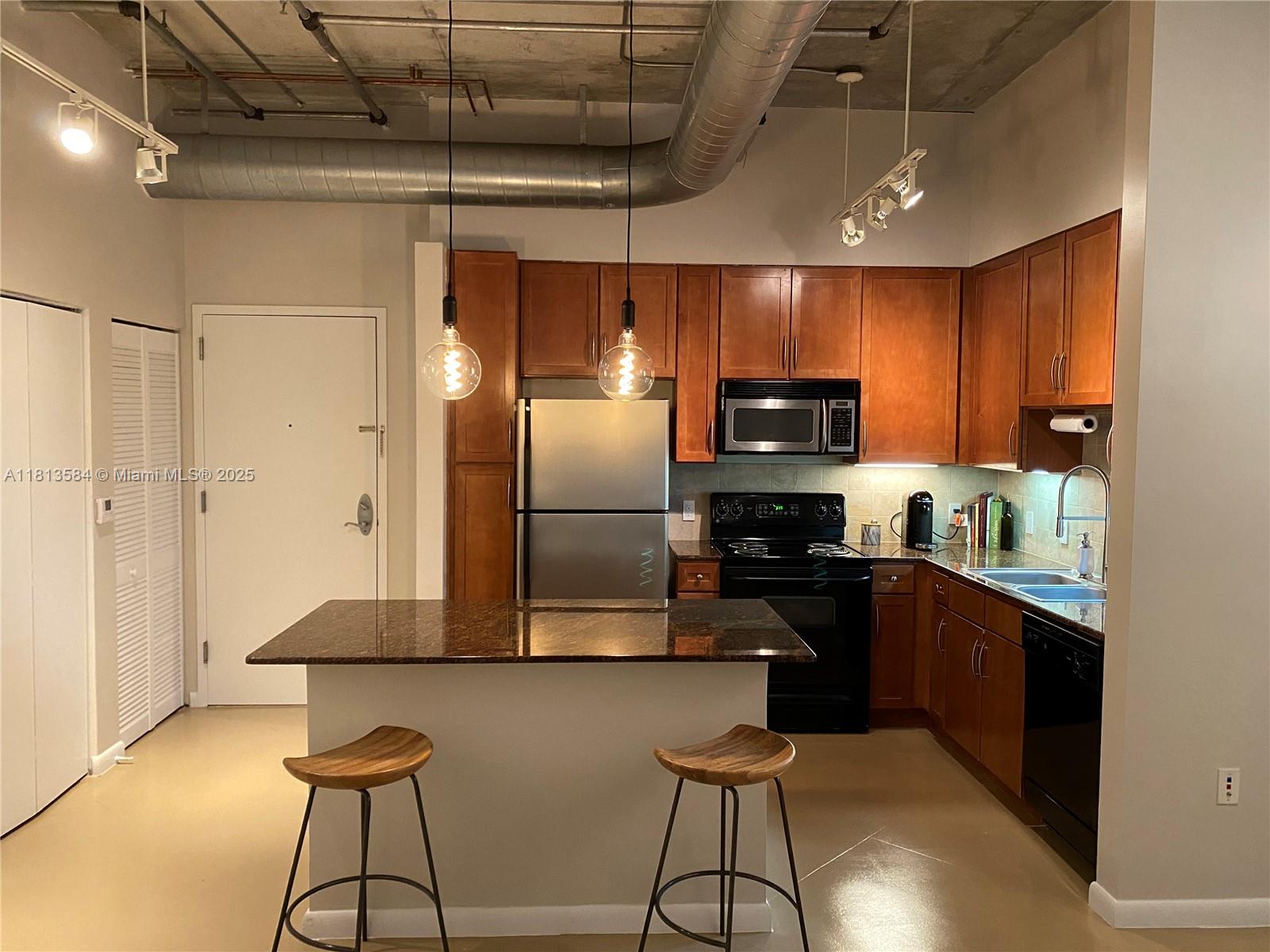 2001 Biscayne Boulevard, Unit 3203 Miami, FL 33137 - Photo 6 of 15 a kitchen with stainless steel appliances granite countertop a refrigerator a stove top oven a sink with island and chairs